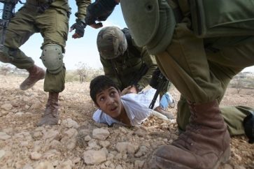 Soldados israelíes detienen a un niño palestino