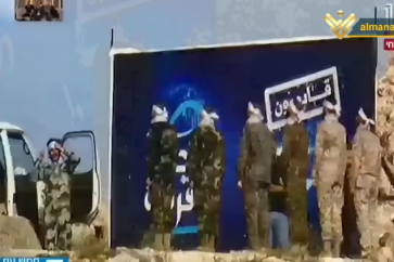 Combatientes de Hezbolá junto a un cartel en la frontera
