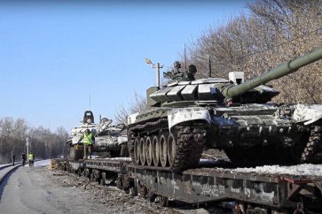 In this photo taken from video provided by the Russian Defense Ministry Press Service on Wednesday, Feb. 16, 2022, Russian army tanks are loaded onto railway platforms to move back to their permanent base after drills in Russia. Russia says it is returning more troops and weapons to bases, but NATO says it sess no sign of a drawdown as fears that Moscow could invade Ukraine soon persist. Russia has massed about 150,000 troops east, north and south of Ukraine. (Russian Defense Ministry Press Service via AP)