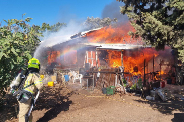 Bombero israelí lucha contra un incendio provocado por un cohete en el asentamiento israelí de Kadita