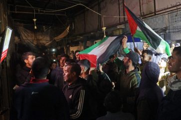 People celebrate along a street at Deir el-Balah in the central Gaza Strip, on January 15, 2025, amid the ongoing war in the Palestinian territory between Israel and Hamas. Crowds of Gazans chanted and embraced on January 15 as news spread that a ceasefire and hostage release deal had been reached between Israel and Hamas aimed at ending more than 15 months of war in the Palestinian territory. (Photo by Eyad BABA / AFP)