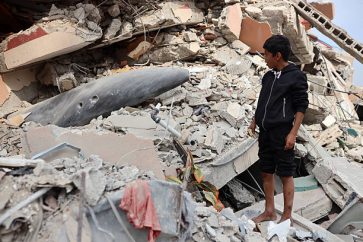A Palestinian boy observes an unexploded missile in the Al-Rimal neighborhood of Gaza City, on November 13, 2025. (Photo by Majdi Fathi/NurPhoto via Getty Images)